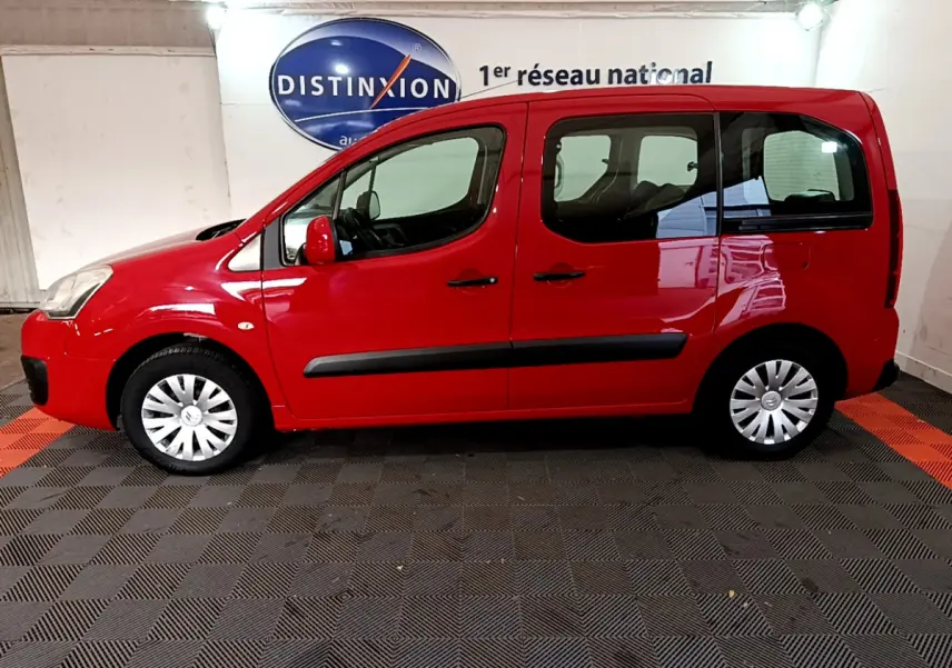 Profil droit d'un Citroën Berlingo rouge de 2016, version BlueHDi 75 BVM Feel, dans un showroom intérieur.