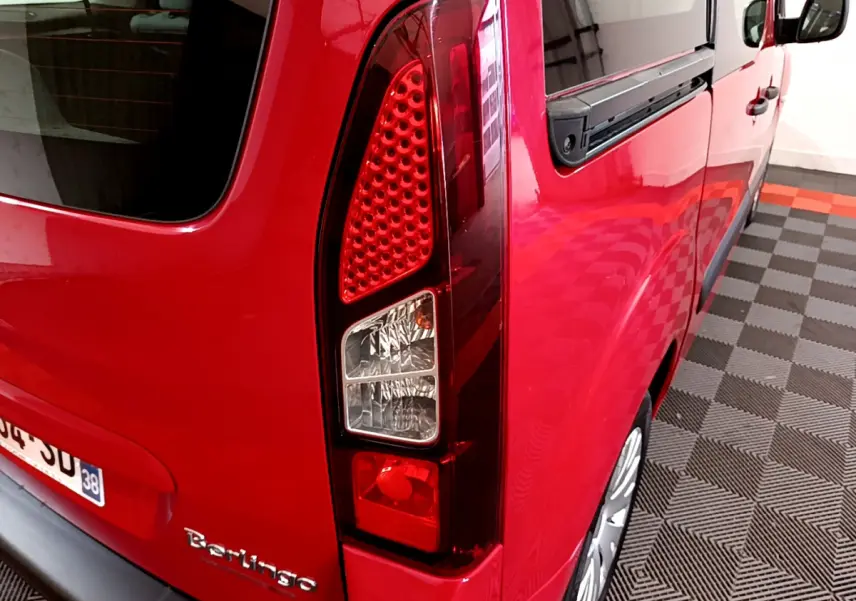Vue arrière côté gauche du Citroën Berlingo rouge 2016, mettant en valeur le feu arrière et la porte arrière.