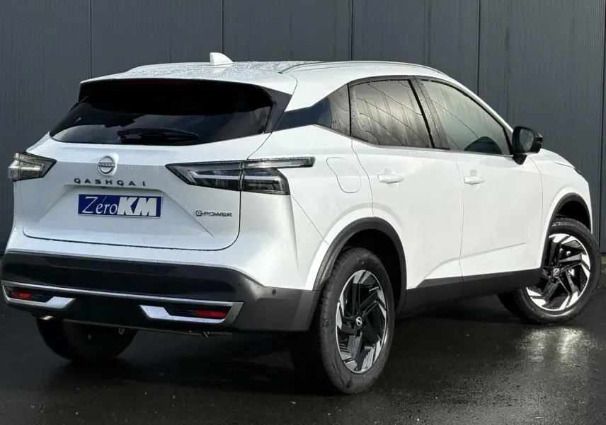 Vue 3/4 arrière droite du Nissan Qashqai blanc nacré e-Power avec jantes alliage et feux arrière LED noirs.