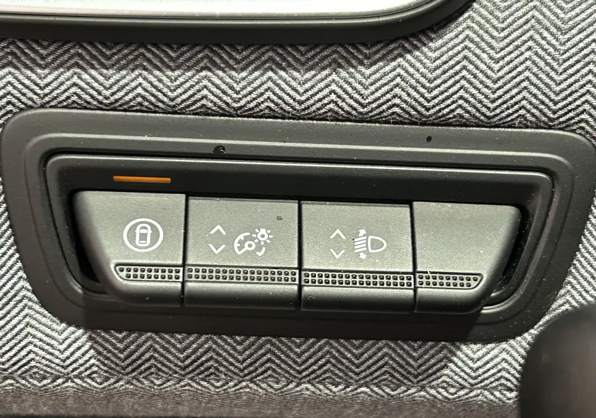 Boutons de réglage des feux et verrouillage sur tableau de bord avec tissu gris à motif chevrons dans Renault Clio V E-Tech.