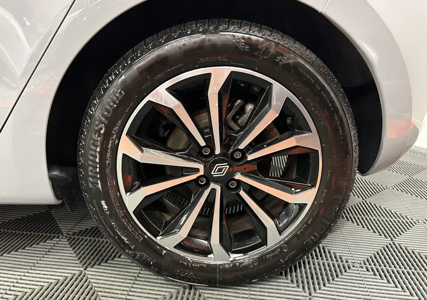 Gros plan sur la roue avant gauche de la Renault Clio V gris Rafale métal avec jante alliage noire et argentée.