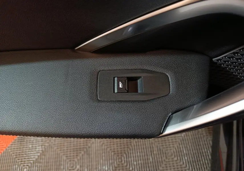 Détail de l'interrupteur de verrouillage des portes sur la porte intérieure côté conducteur d'un BMW X1 noir 2023.