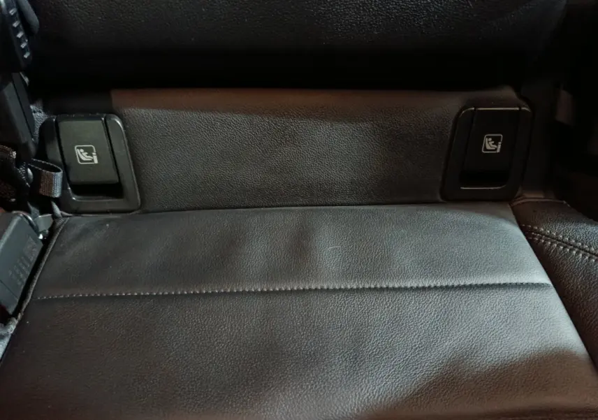 Gros plan sur la banquette arrière noire en cuir du BMW X1 xDrive23i M Sport, avec boutons de rabattement des sièges.