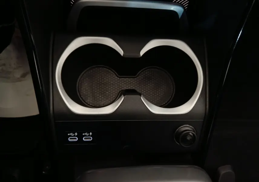 Gros plan sur la console centrale noire du BMW X1 xDrive23i M Sport 2023 avec porte-gobelets et ports USB-C.