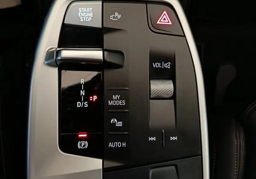 Gros plan sur la console centrale noire et argentée du BMW X1 xDrive23i M Sport avec commandes de boîte auto et volume.