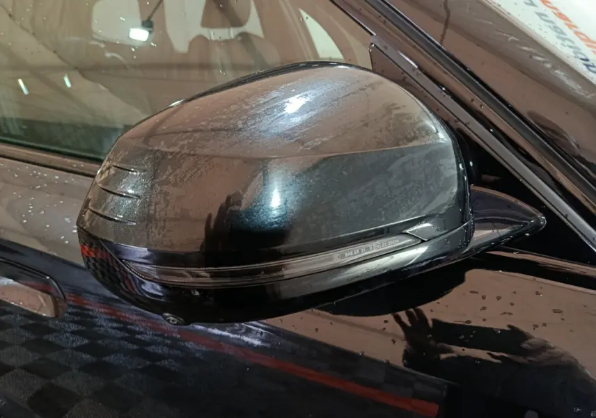 Rétroviseur côté gauche noir brillant de BMW X1 xDrive23i M Sport 2023 avec clignotant intégré, vue rapprochée.