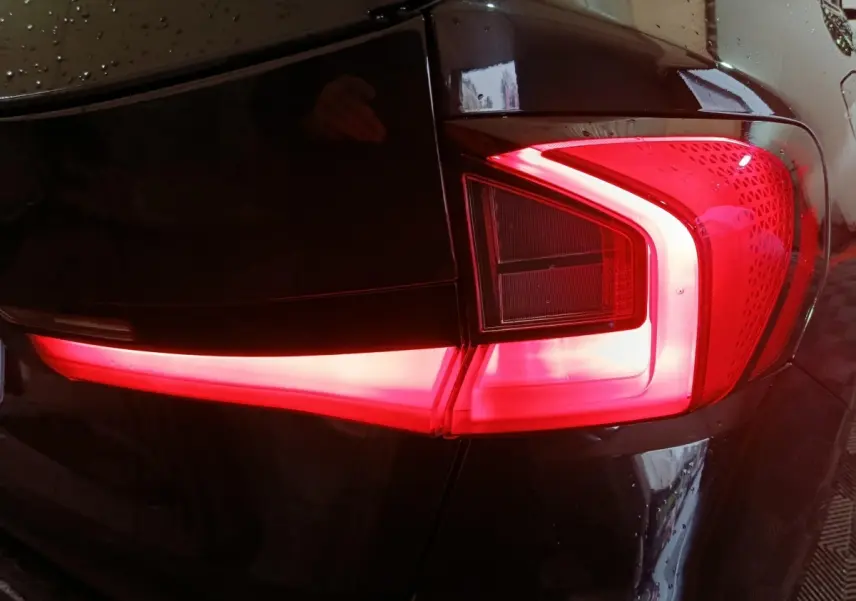 Gros plan sur le feu arrière droit allumé d’un BMW X1 noir xDrive23i M Sport 2023.