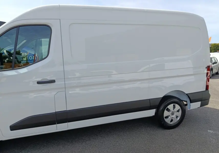 Vue de profil côté droit d’un utilitaire Renault Master blanc avec porte latérale coulissante et jantes acier.