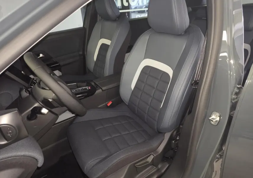 Vue intérieure côté conducteur du Citroën C5 Aircross 2026, sièges tissu bleu avec insert clair et volant multifonctions.