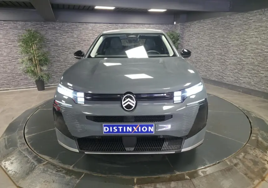 Vue avant d'une Citroën C5 Aircross 2026 gris métallisé avec calandre noire et feux LED allumés.