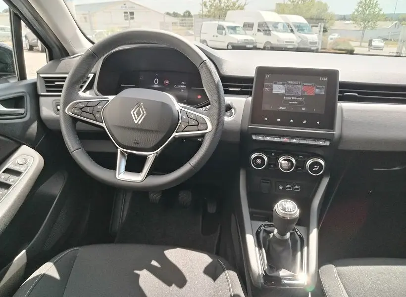 Vue intérieure avant centrée sur le volant multifonction et la console centrale avec écran tactile de la Renault Clio V TCE 90 Evolution.