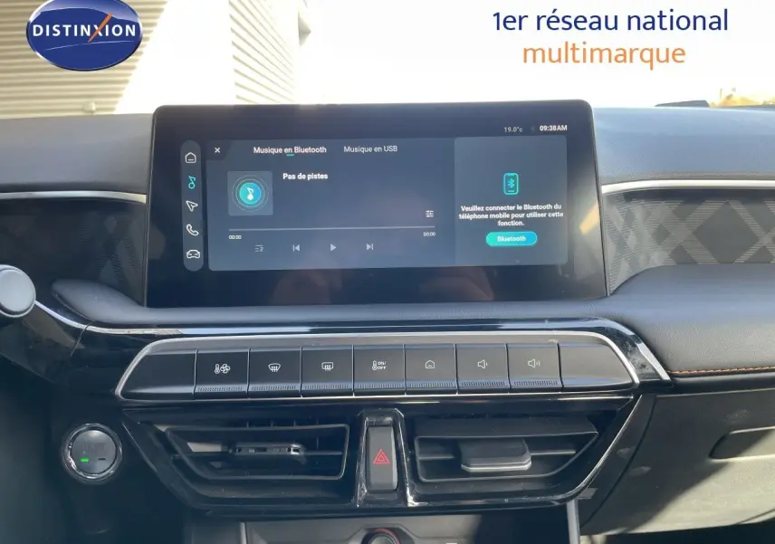 Tableau de bord du MG3 2024 en vue frontale, écran tactile central affichant la musique Bluetooth, finition noire avec surpiqûres marron.
