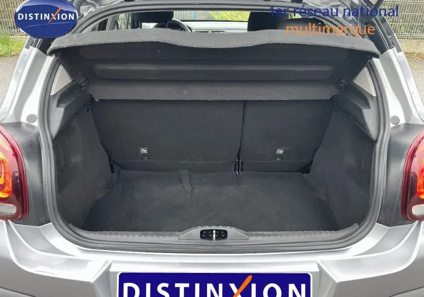 Coffre ouvert d'une Citroën C3 2023 gris acier métal avec toit noir, vue arrière montrant l'espace de chargement vide.