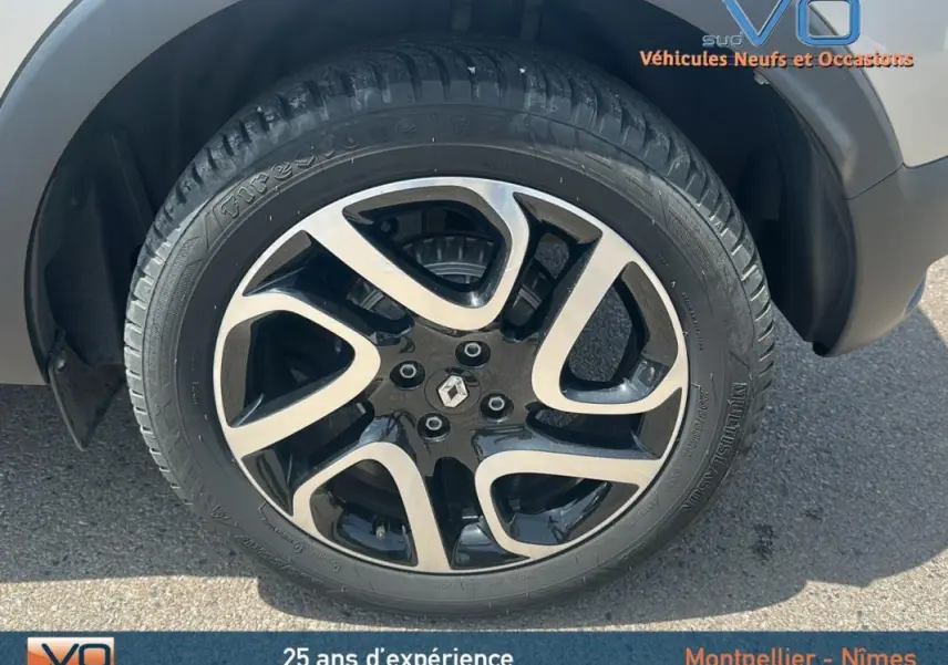 Gros plan sur la jante alliage 16 pouces noire et argentée du Renault Captur gris clair côté droit.