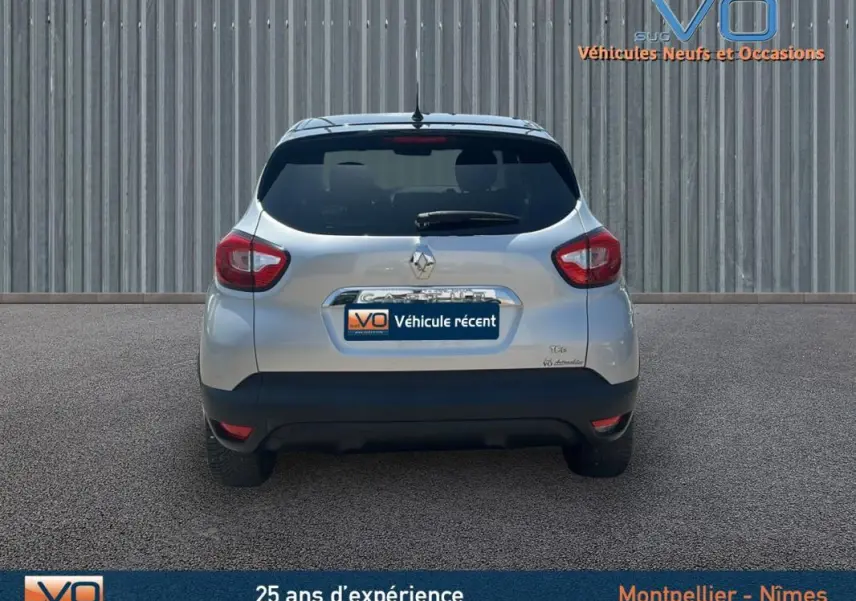 Vue arrière d'un Renault Captur gris clair TCe 120 Energy Zen EDC de 2016 avec feux arrière et lunette teintée.