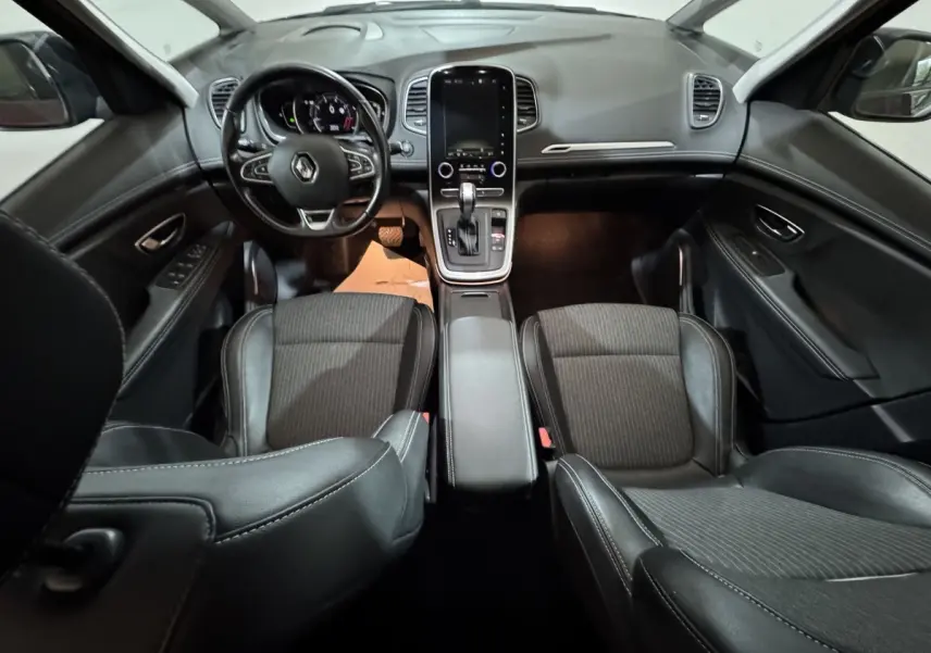Intérieur noir du Renault Scénic Intens 2021, vue frontale du tableau de bord avec écran tactile vertical et volant multifonction.