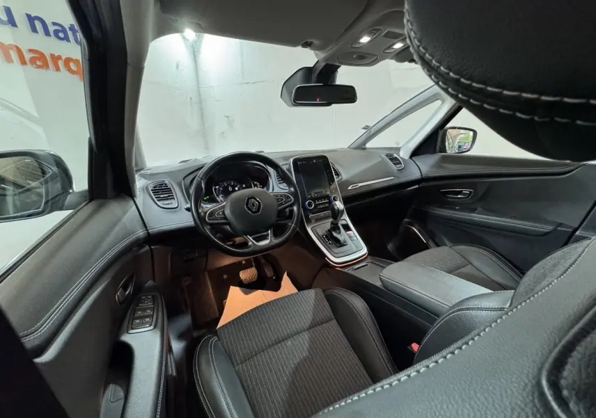 Intérieur du Renault Scénic Intens 2021 vu côté conducteur, tableau de bord moderne avec écran tactile central et sièges noirs.