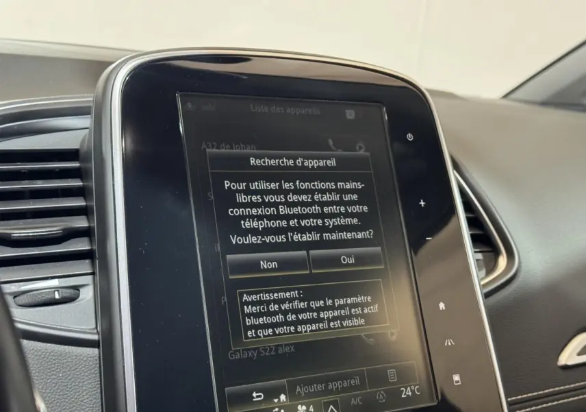 Écran tactile central affichant la connexion Bluetooth dans l’habitacle gris du Renault Scénic Intens rouge.