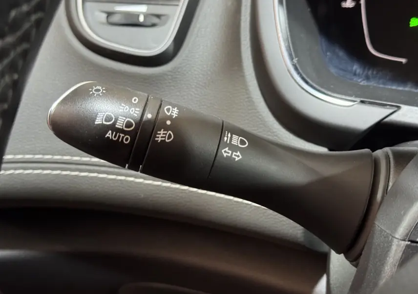 Gros plan sur la commande des phares et clignotants dans l'habitacle du Renault Scénic Intens rouge 2021.