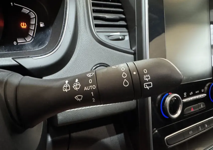 Gros plan sur la commande d'essuie-glace noire dans l'habitacle du Renault Scénic Intens rouge 2021, avec tableau de bord et écran tactile visibles.