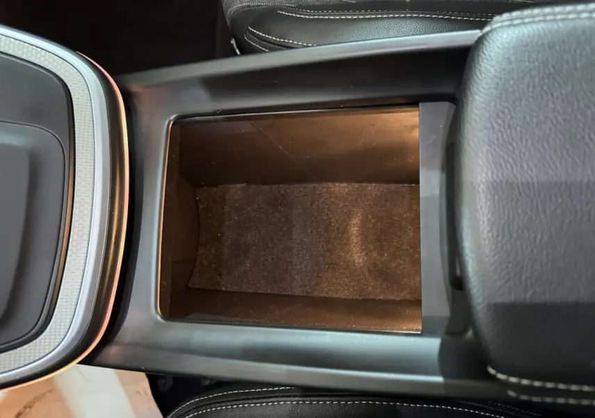 Vue plongeante sur le rangement central noir entre les sièges du Renault Scenic Intens TCe 160 EDC 2021.