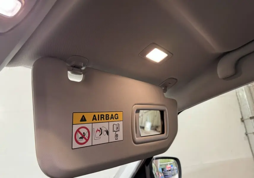 Pare-soleil intérieur côté gauche avec avertissement airbag et miroir, dans un Renault Scenic rouge 2021 Intens TCe 160 EDC.