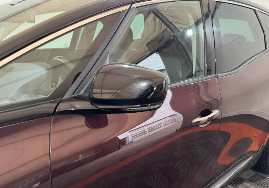 Vue côté gauche rapprochée du Renault Scénic Intens rouge 2021 avec rétroviseur noir et poignée chromée.