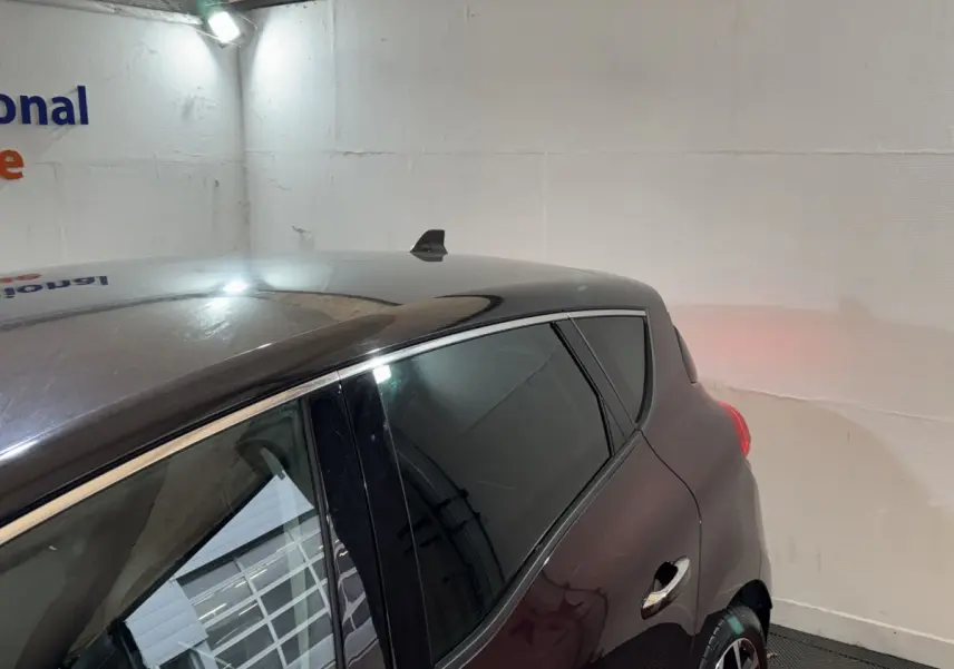 Vue 3/4 arrière droit d'un Renault Scénic Intens TCe 160 rouge avec toit noir et vitres teintées.