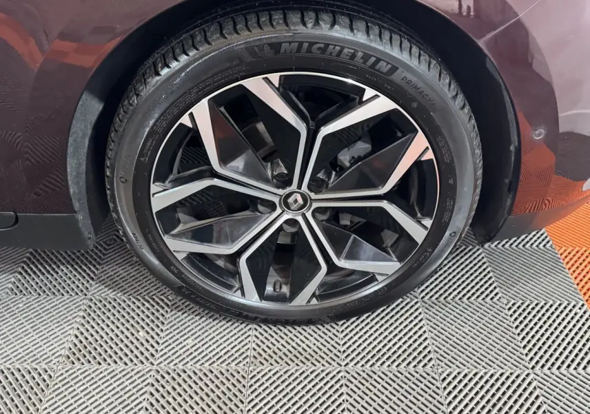 Gros plan sur la roue avant droite du Renault Scenic Intens rouge 2021 avec jante alliage noire et argentée.