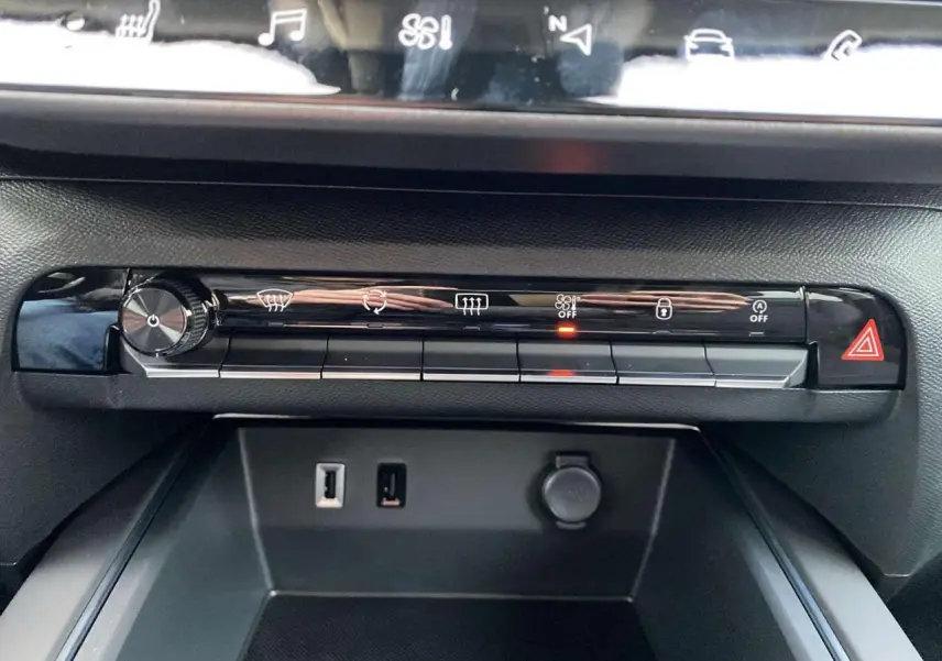 Vue rapprochée de la console centrale du Citroën C5 Aircross 2025, avec commandes climatisation et prises USB visibles.