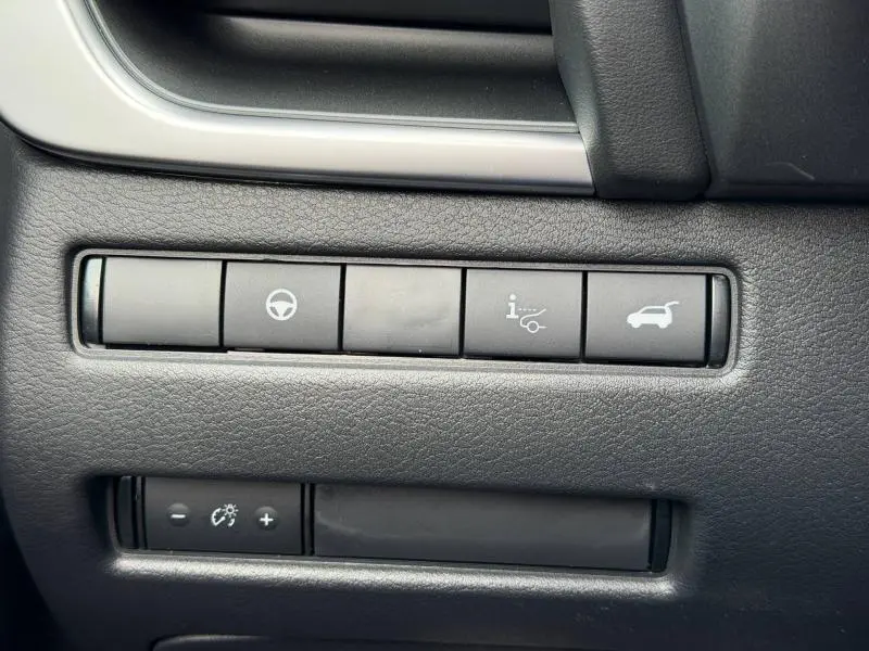 Gros plan sur les boutons de commande noirs du tableau de bord du Nissan Qashqai Hybrid e-POWER gris Squale.