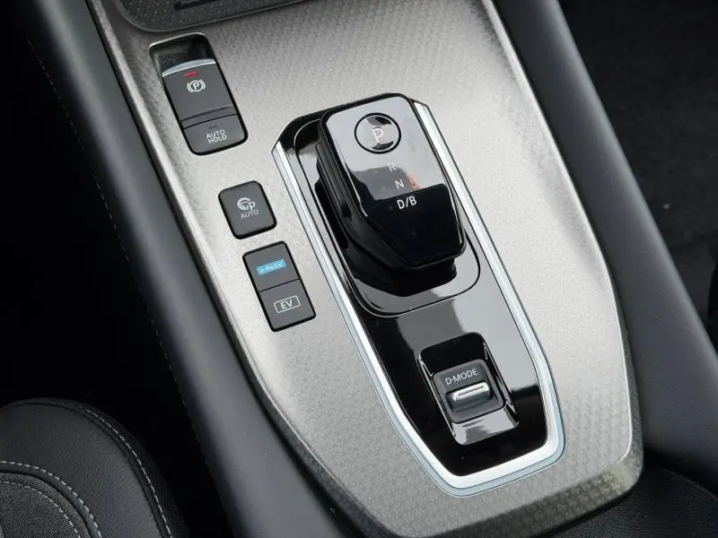 Vue rapprochée de la console centrale du Nissan Qashqai Hybrid e-POWER 2025 avec levier de vitesses noir brillant et commandes autour.
