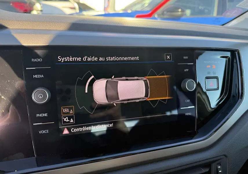 Écran central du Volkswagen Polo 2021 gris métal montrant le système d'aide au stationnement en vue de dessus.