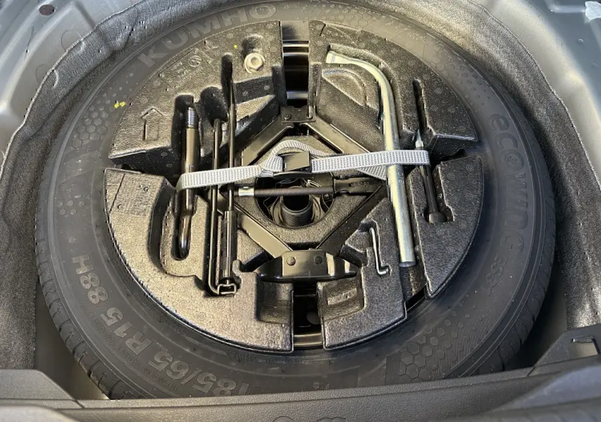 Gros plan sur la roue de secours et les outils de bord dans le coffre d'une Volkswagen Polo gris métal 2021.