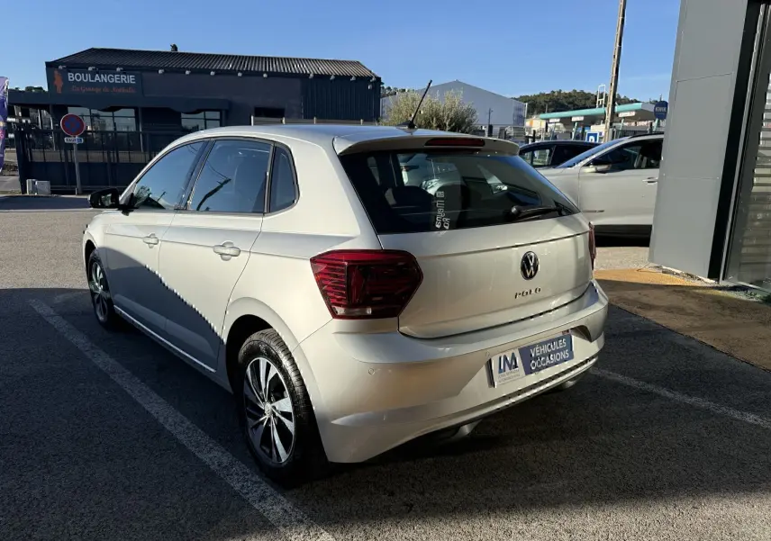 Vue 3/4 arrière droite d'une Volkswagen Polo gris métal 2021 avec feux arrière foncés et jantes alliage.