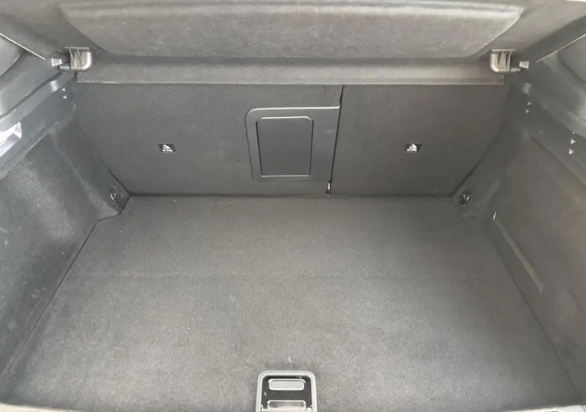 Coffre vide vu de face du DS4 E-Tense 2023, revêtement intérieur noir avec trappe centrale au fond.