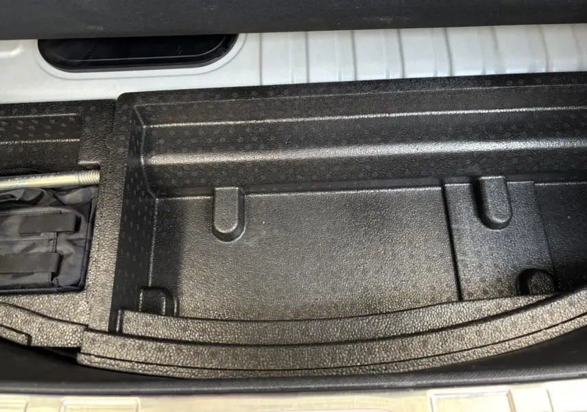 Gros plan sur le compartiment de rangement noir texturé dans le coffre du DS4 E-Tense 2023.