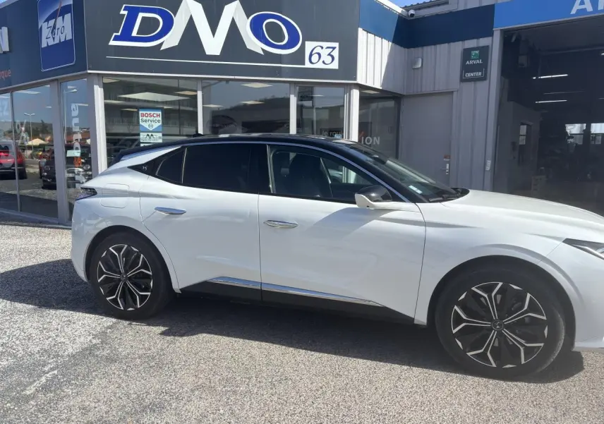 Vue latérale droite d'une DS4 2023 blanche avec toit noir Perla Nera, jantes alliage et poignées affleurantes chromées.