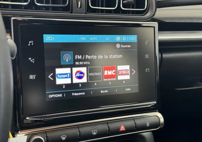 Vue rapprochée de l'écran tactile central du tableau de bord de la Citroën C3 gris foncé, affichant les stations radio FM.