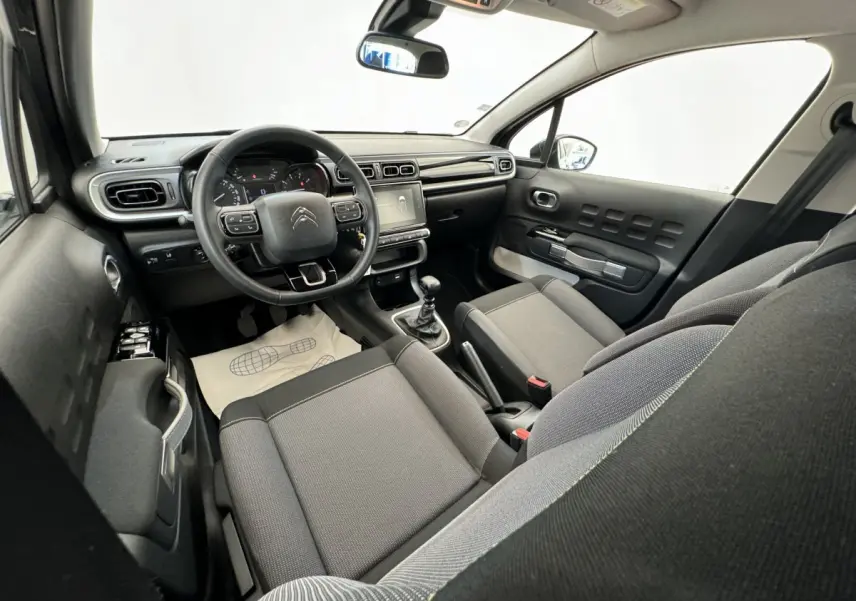 Vue intérieure avant droite de la Citroën C3 2020, sièges gris, volant cuir multifonctions et écran tactile central.