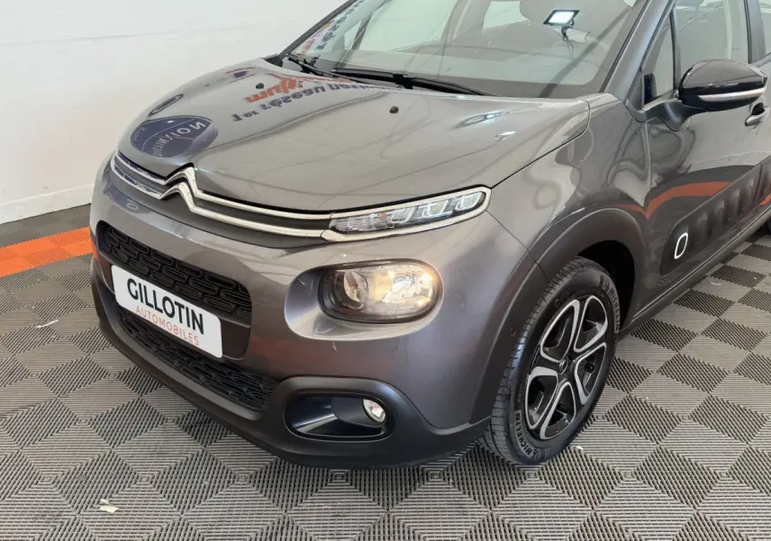 Vue 3/4 avant droit d'une Citroën C3 gris foncé avec phares LED et jantes alliage distinctives.