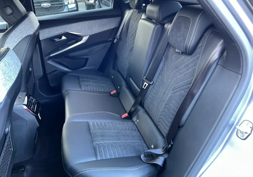 Vue intérieure côté droit montrant la banquette arrière en cuir et alcantara gris avec ceintures de sécurité noires.