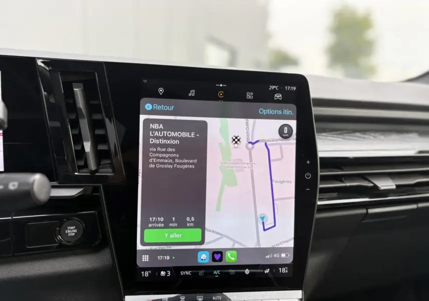 Écran tactile central du Renault Espace VI bleu Nuit affichant la navigation GPS avec interface moderne et commandes climatisation.