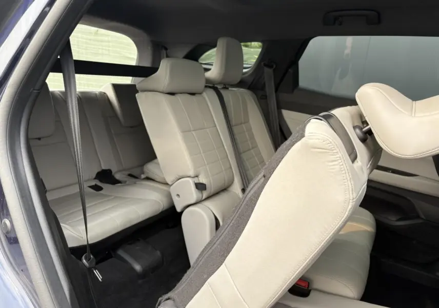 Vue intérieure côté droit du Renault Espace bleu nuit 2023, montrant les sièges arrière en cuir gris sable clair.