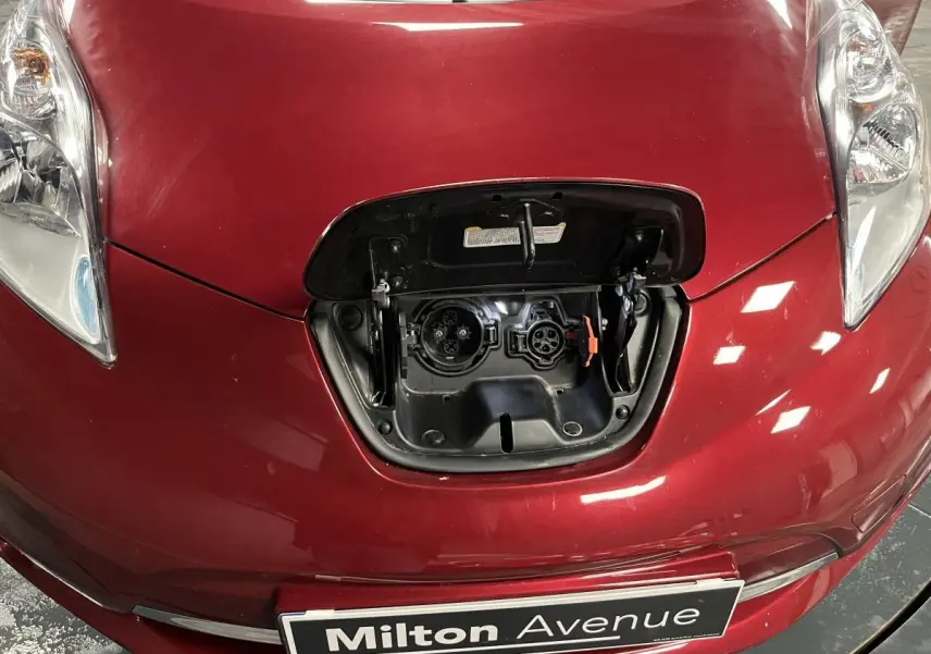 Vue rapprochée de l'avant rouge d'une Nissan LEAF 2017 avec la trappe de recharge électrique ouverte.
