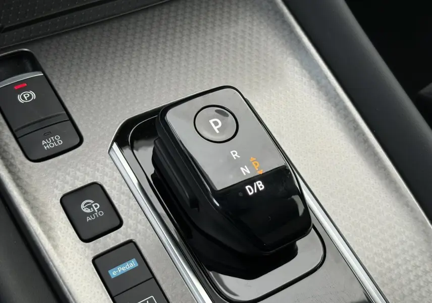 Vue rapprochée du sélecteur de boîte automatique noir sur console gris métallisé du Nissan Qashqai III e-Power 2025.