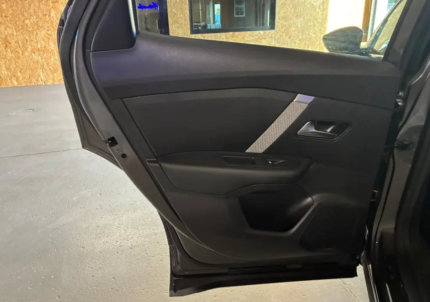 Vue rapprochée de la porte arrière droite grise du Citroën C4 X 2024, avec garniture noire et insert décoratif argenté.