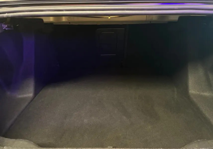 Coffre ouvert de la Citroën C4 X 1.5 BlueHDi 130 gris 2024, montrant un espace de chargement vide et propre.