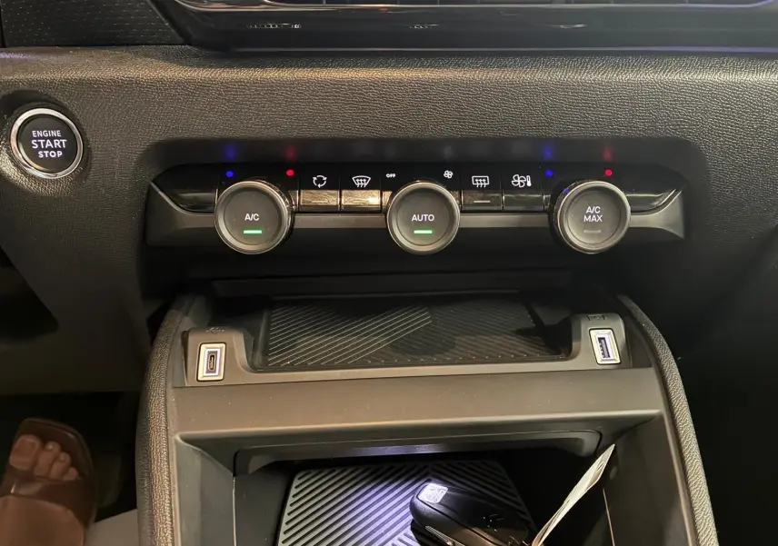 Gros plan sur la console centrale du Citroën C4 X gris 2024, montrant les commandes de climatisation et ports USB.
