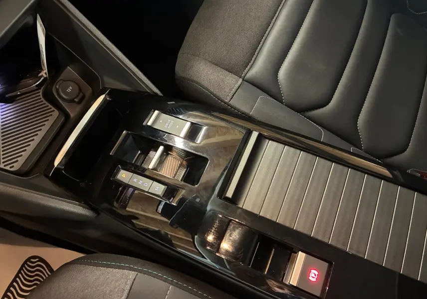 Vue rapprochée de la console centrale noire brillante et du siège tissu gris-noir de la Citroën C4 X 1.5 BlueHDi 130 2024.